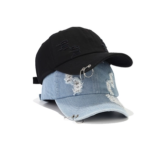 Nahaufnahme von Distressed-Denim-Basecaps mit Metallringen und Rissen im Vintage-Stil