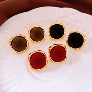 Close-up of velvet flocking square stud earrings in dark brown, black, and red colors