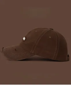 Detail of distressed dark brown baseball cap with embroidery and frayed brim texture