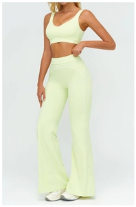 Detail of high-waist flared yoga pants and v-neck sports bra in pale lime green fabric