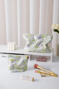 Close-up of floral jacquard cosmetic bags with metal flower zipper and brand label