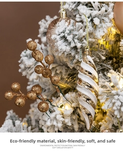 Close-up of white and gold Christmas ornaments with glitter berries and textured baubles