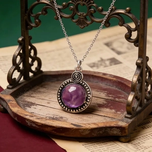 Macro d'un pendentif vintage en résine violette avec cadre en argent gravé et décor spirale