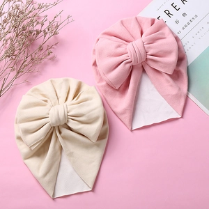 Winter infant beanie hats in pink and beige featuring large handmade bow details