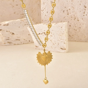 Detail of gold heart pendant necklace with baguette zircon and coffee bean link chain