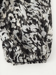 Detailaufnahme der elastischen Manschetten und monochromer abstrakter Druck auf Chiffon