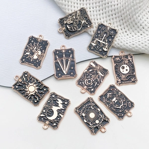 Detailed close-up of tarot card charms featuring The Lovers and The Sun in black gold finish