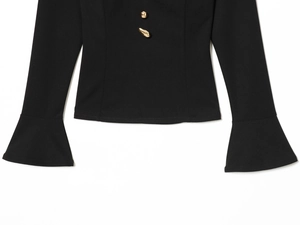 Detail of elegant black long-sleeve top with flared cuffs and decorative gold buttons