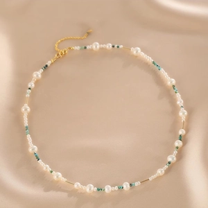 Detail of double-layer natural pearl necklace with turquoise accents and gold tubes