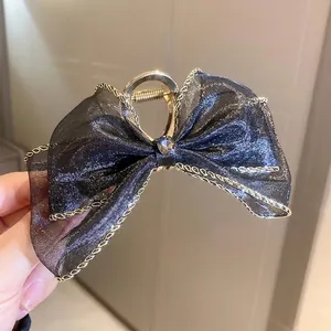 Pince à cheveux élégante avec nœud en maille noire, diamant camélia et chaîne dorée