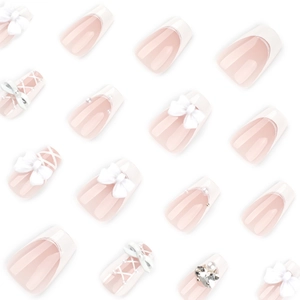 White French fake nails with 3D bows, pearls, and rhinestones on soft pink base