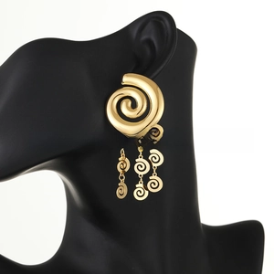 Macro shot of 18k gold plated layered spiral leaf tassel earrings on a model bust