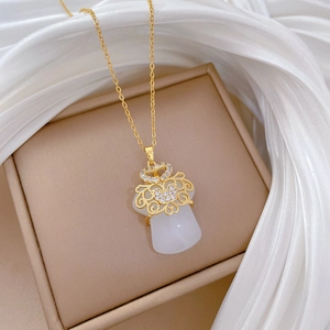 Close-up of gold titanium necklace with sparkling rhinestones and white jade pendant