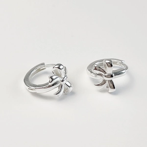 Macro detail of 925 sterling silver bow knot hoop earrings on a neutral background