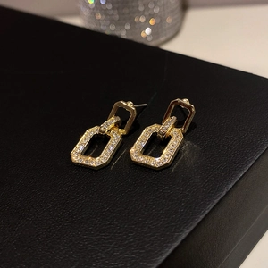 Macro detail of gold geometric rectangle earrings with sparkling pave-set stones