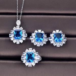 Detailed set featuring emerald-cut blue gemstone necklace, earrings and ring in silver