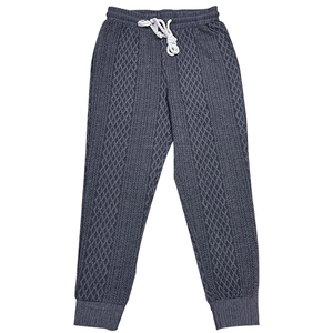 Close-up of grey knitted joggers featuring white drawstring and textured diamond pattern
