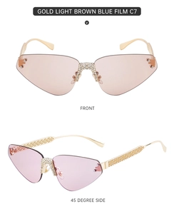 Détail de lunettes de soleil œil-de-chat sans monture avec strass et branches dorées ajourées
