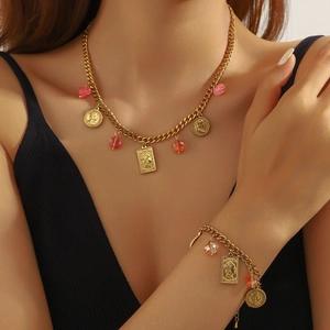Golden coin and pink gemstone pendant necklace and bracelet set on model