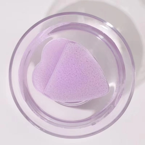 Macro view of purple heart-shaped sponge expanding in water inside a transparent jar