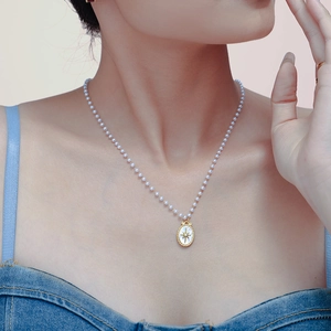 Elegante collana di perle con ciondolo ovale dorato a raggiera e stella centrale