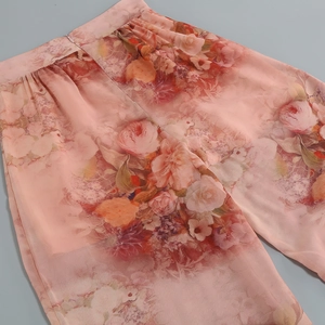 Detail of pink floral chiffon wide-leg trousers with elastic waistband and zipper