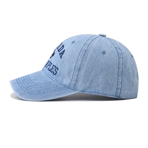 Détail d'une casquette de baseball en jean délavé bleu clair avec broderie de lettres