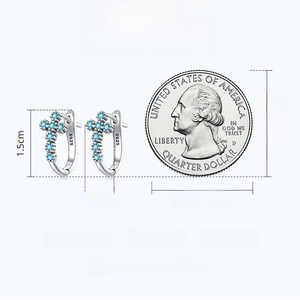 Size comparison of S925 silver cross earrings with blue zircon against a quarter coin