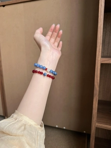 Close-up of agarwood and agate beaded bracelets on a wrist with deep blue crystals