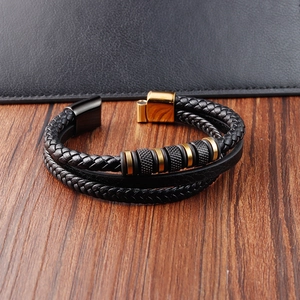Close-up of black and gold multilayer braided leather bracelet with magnetic metal clasp