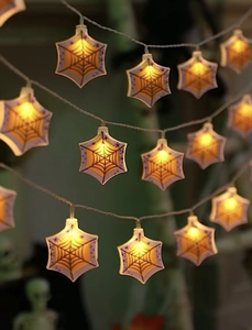 Close-up of LED spider web fairy lights with warm yellow glow for Halloween decor