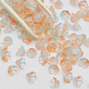 Macro shot of lily of the valley glass beads in orange and blue gradient for DIY jewelry