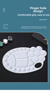 Macro detail of white plastic palette with thumb hole and petal-shaped mixing wells