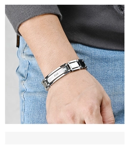 Close-up of men's two-tone DAD watch band bracelet worn on wrist with silver and black steel