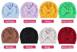 Flat lay of soft ribbed newborn turban hats with large bows in eight pastel colors