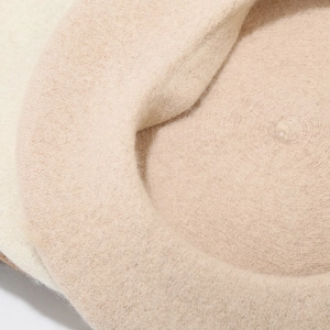 Detailopname van beige wollen vilten baret met dikke textuur en Frans vouwsilhouet