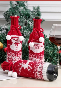 Close-up of red knitted Christmas wine bottle covers with snowman and elk patterns