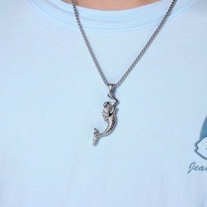 Detail of silver mermaid pendant with intricate 3D textures on a metal hip-hop chain