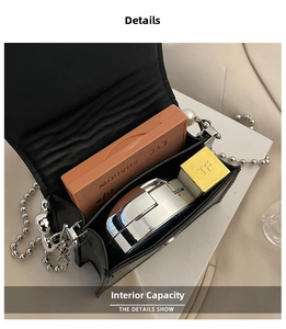 Detail view of the black flap bag interior with pearl chain and cosmetics inside