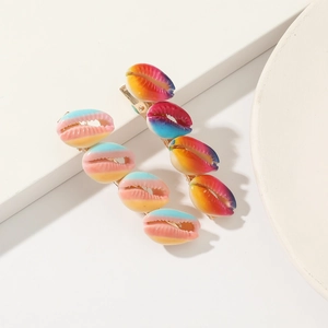 Set of two colorful rainbow gradient shell-shaped hair clips on a white background