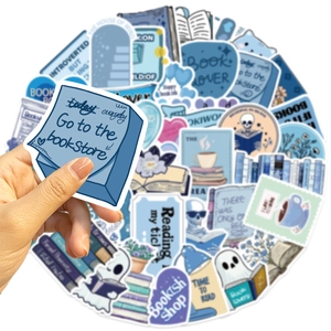 Close-up of hand holding blue book lover stickers for laptop and guitar decoration