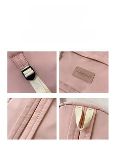 Detail view of pink canvas backpack featuring durable handle and brand logo patch