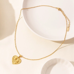 Golden heart-shaped pendant necklace with 18k plating and embossed skull texture