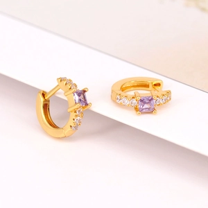 Detail of gold C-shaped earrings with square purple stone and pavé zircon accents