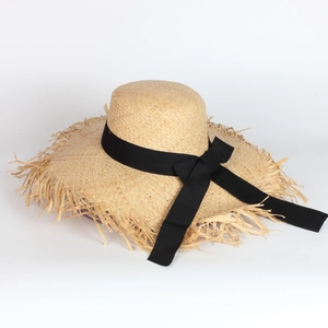 Beige raffia sun hat with wide brim, frayed edges and elegant black ribbon bow