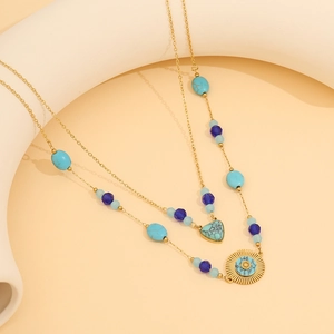 Vintage gold layered necklace with turquoise heart, sun pendant, and blue beaded chain links