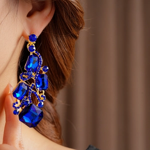 Detailed close-up of a vintage square earring featuring deep blue crystals in gold setting
