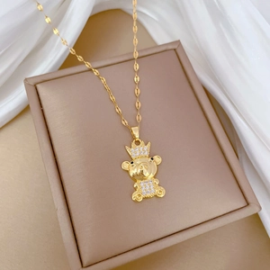 Detailed close-up of golden crown bear pendant with sparkling crystals on a cross chain
