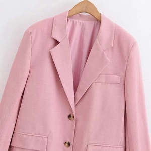 Fashionable pink single-breasted blazer for women with notch lapel on wooden hanger
