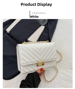 Close-up of white quilted leather bag featuring V-shaped stitching and gold chain strap